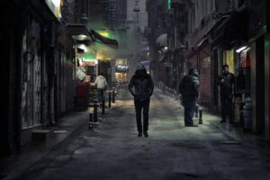 Un hombre camina solo por los callejones de la ciudad durante la noche.